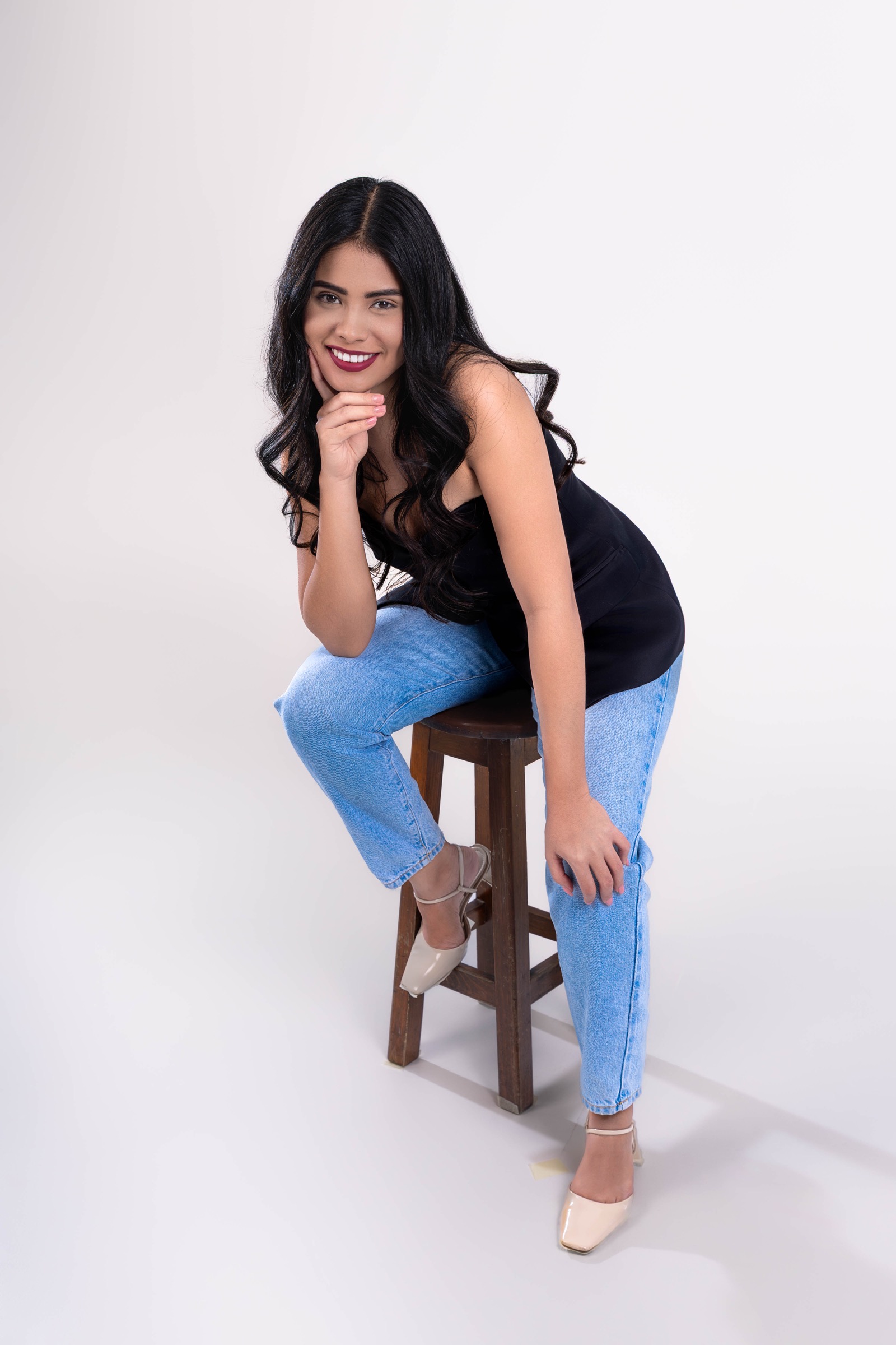 Retrato de una mujer sentada en estudio con fondo claro