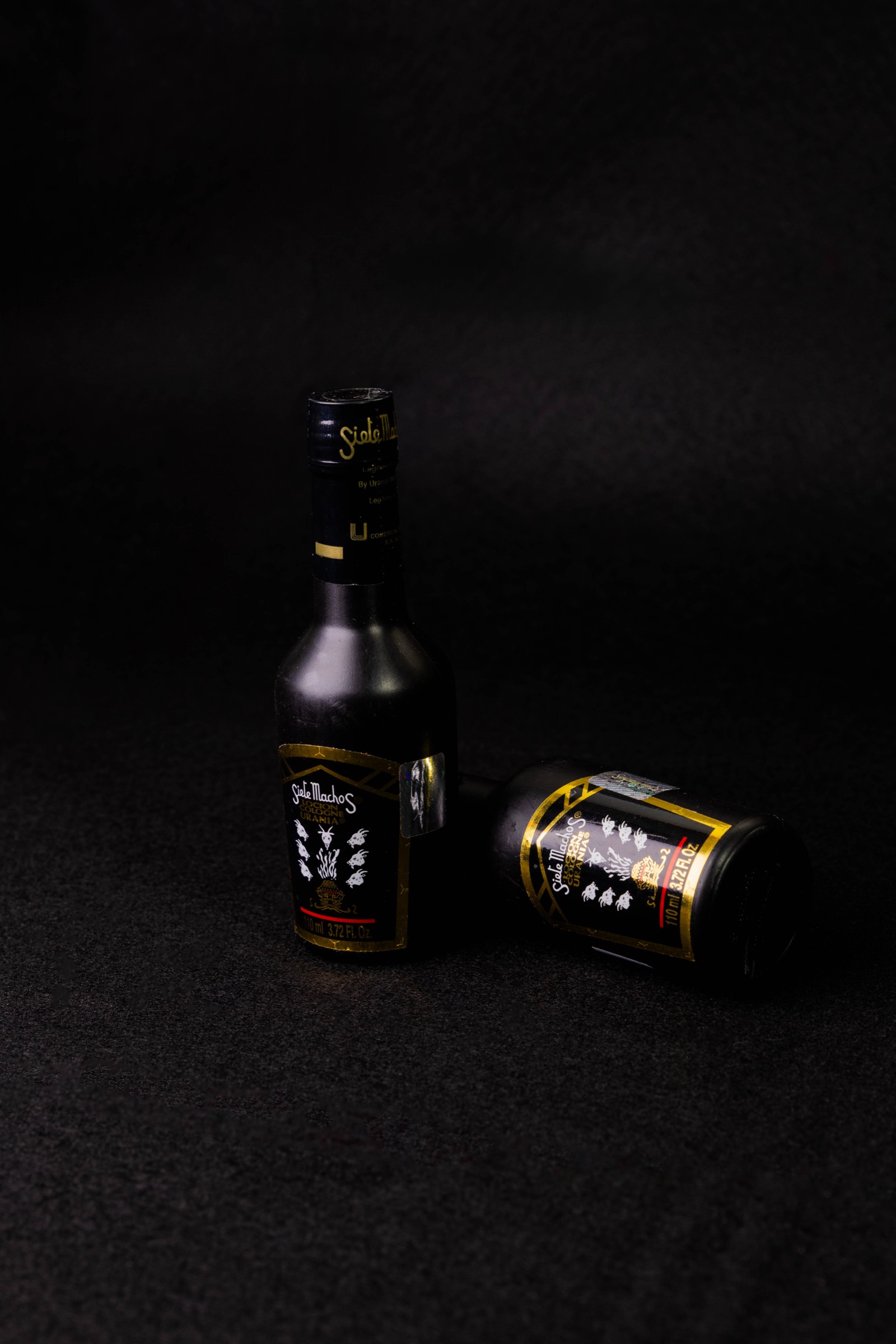 Fotografía de producto de botellas oscuras sobre fondo negro