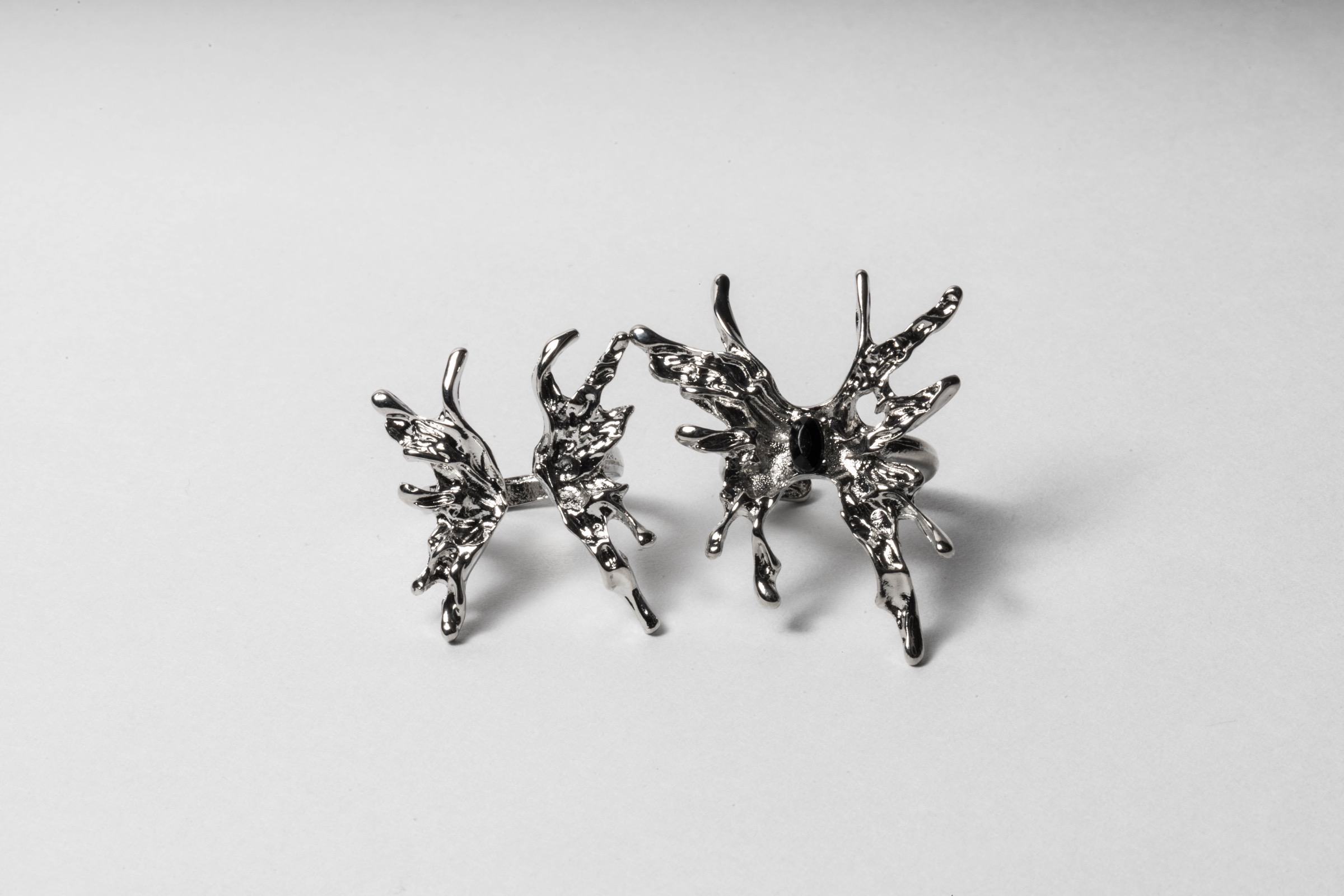 Fotografía de producto de un par de aretes plateados sobre fondo claro