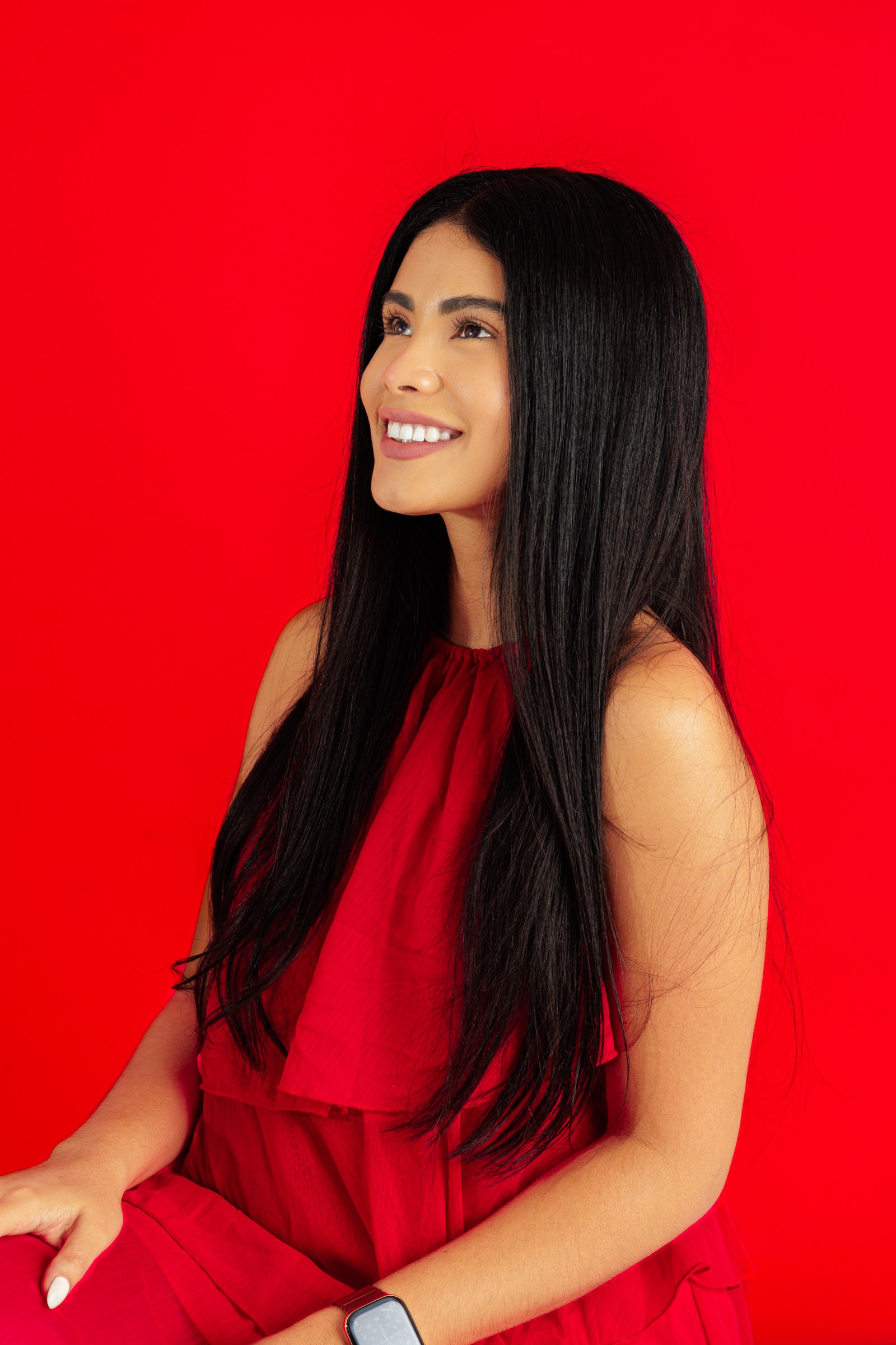 Retrato de una mujer con vestido rojo frente a un fondo rojo
