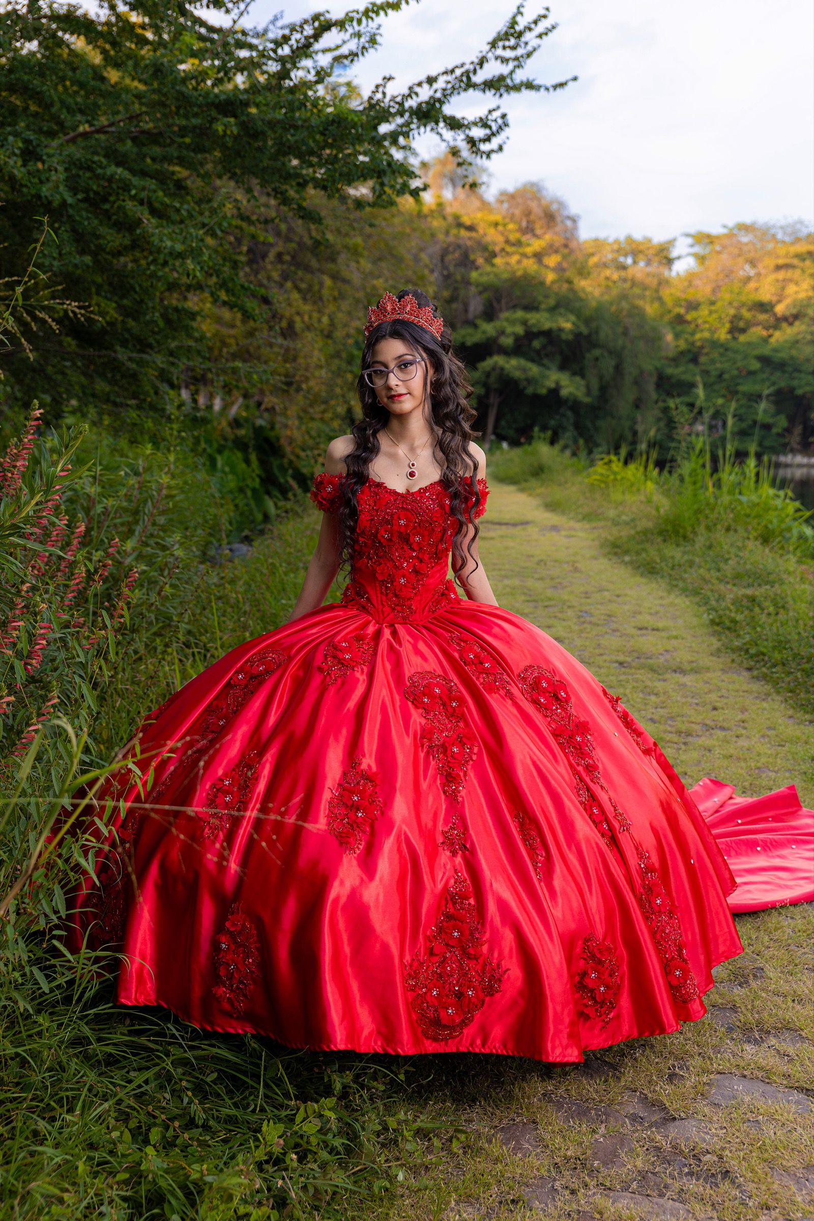 Retrato de una joven con vestido rojo en un sendero