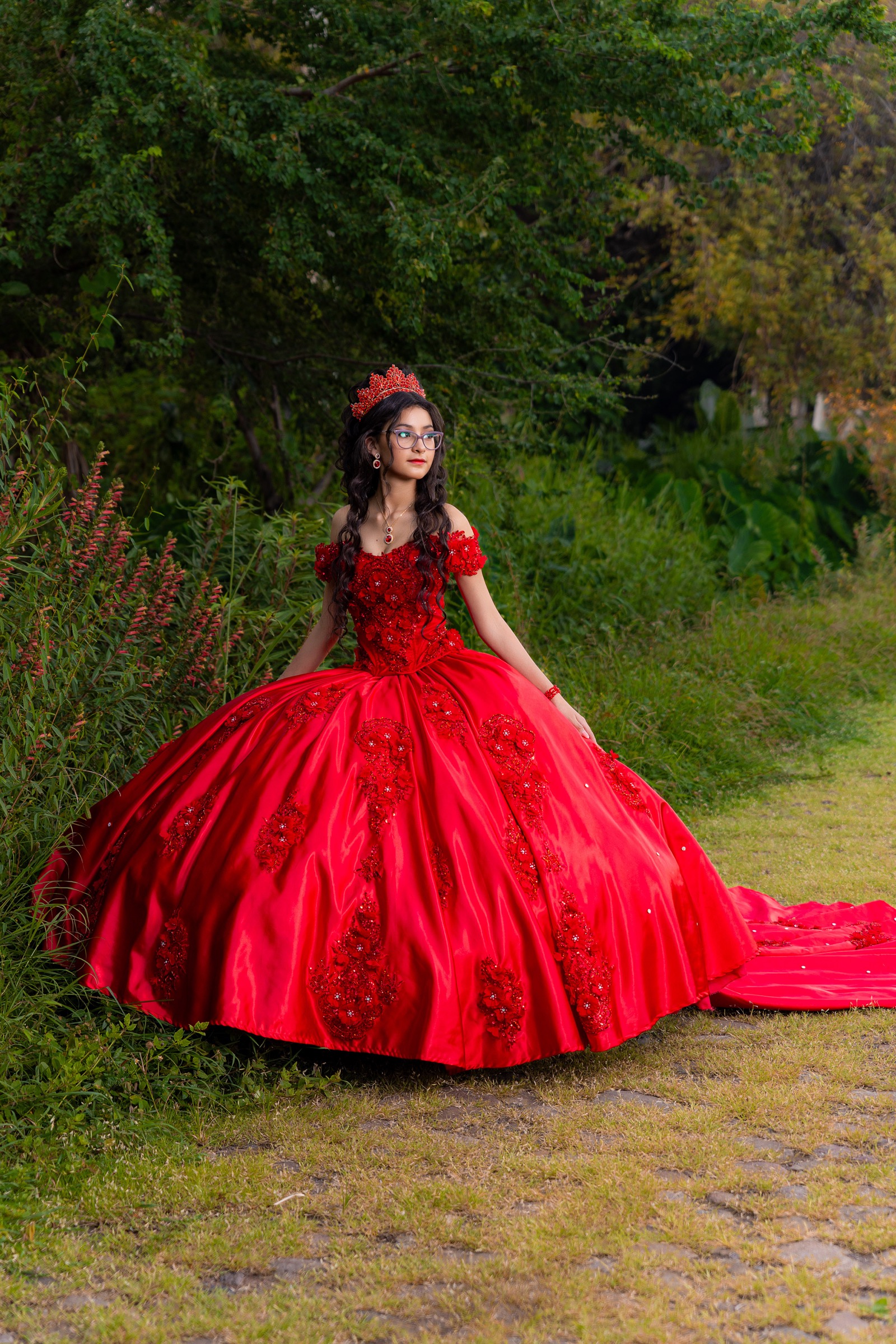 Retrato de una joven con vestido rojo en un jardín
